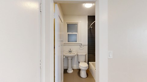 A bathroom with a toilet, sink and mirror.