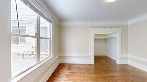 A room with a window and wooden floors.