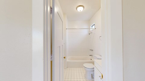 A white bathroom with a toilet, sink and bathtub.