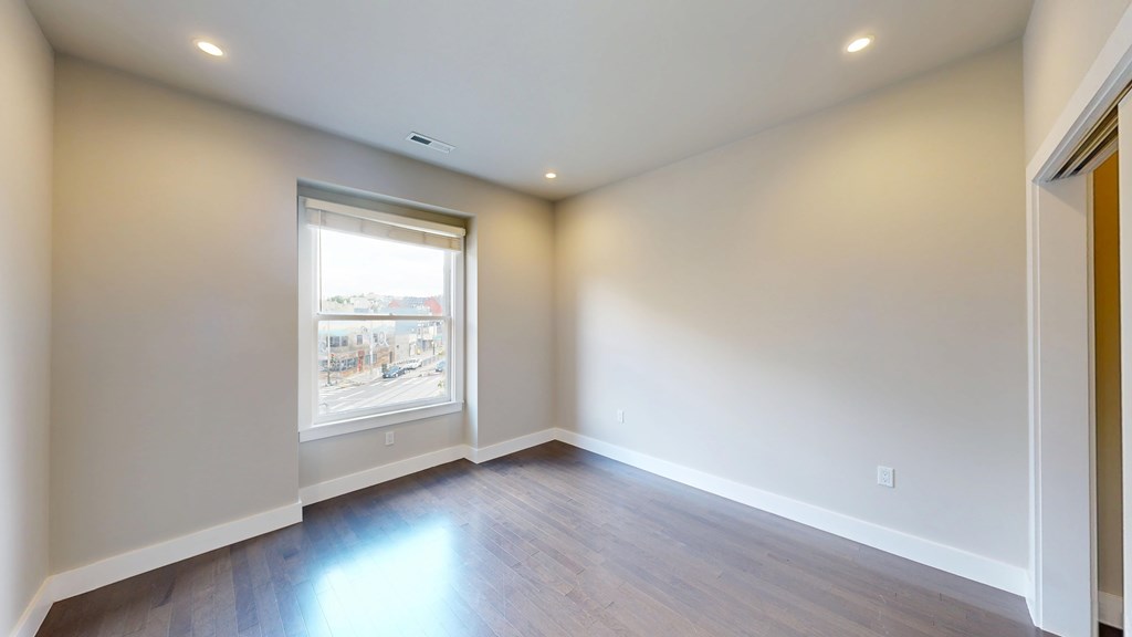 A room with a window and wooden floors.