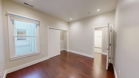 A room with a window and wooden floors.