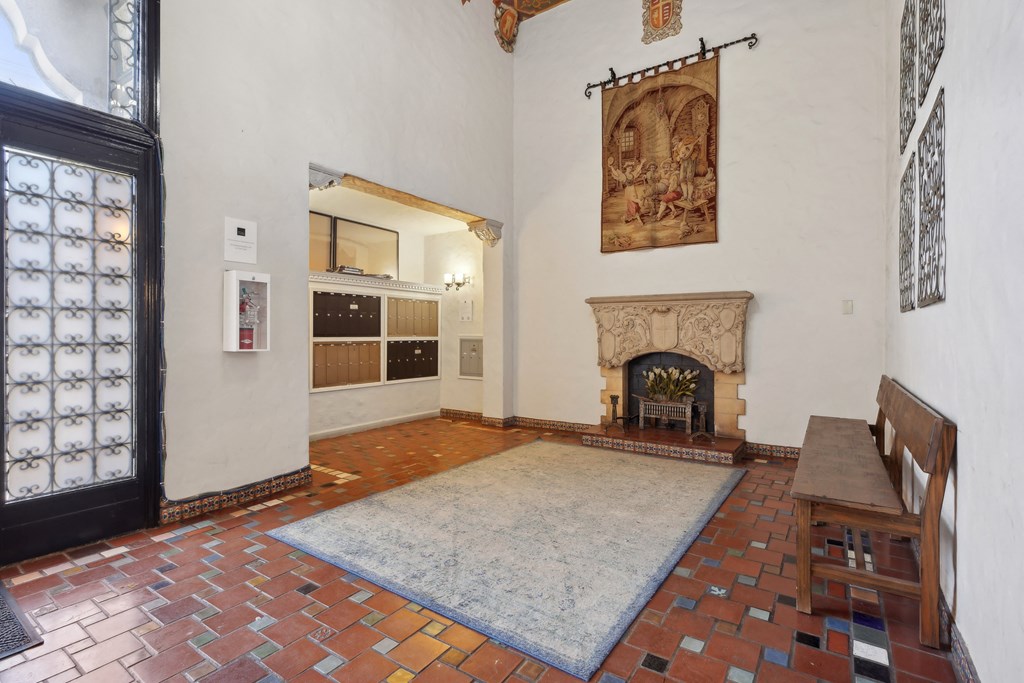 Spacious lobby with a high ceiling, a fireplace with a wooden bench