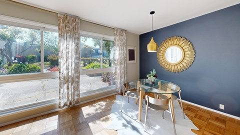 A sunny dining room with a glass table and chairs.