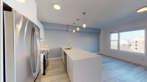 a white kitchen with a large island and stainless steel appliances