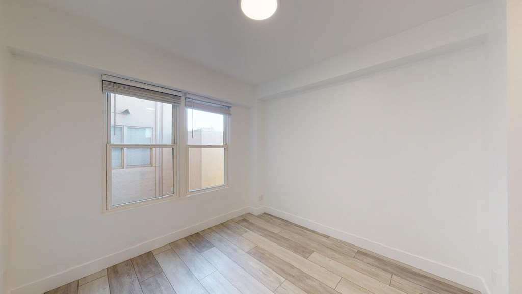 a living room with white walls and wood floors