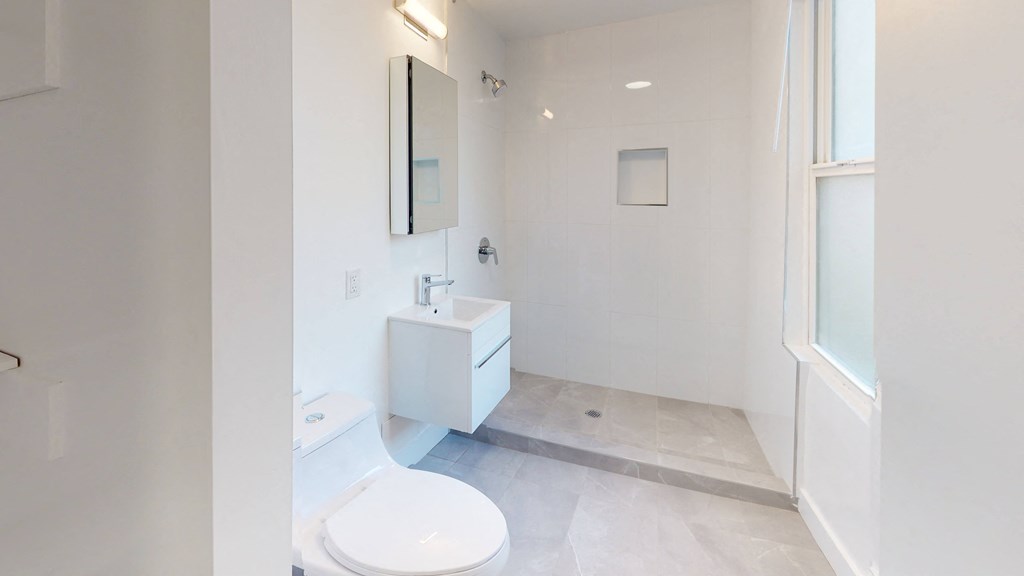 a white bathroom with a toilet and a sink