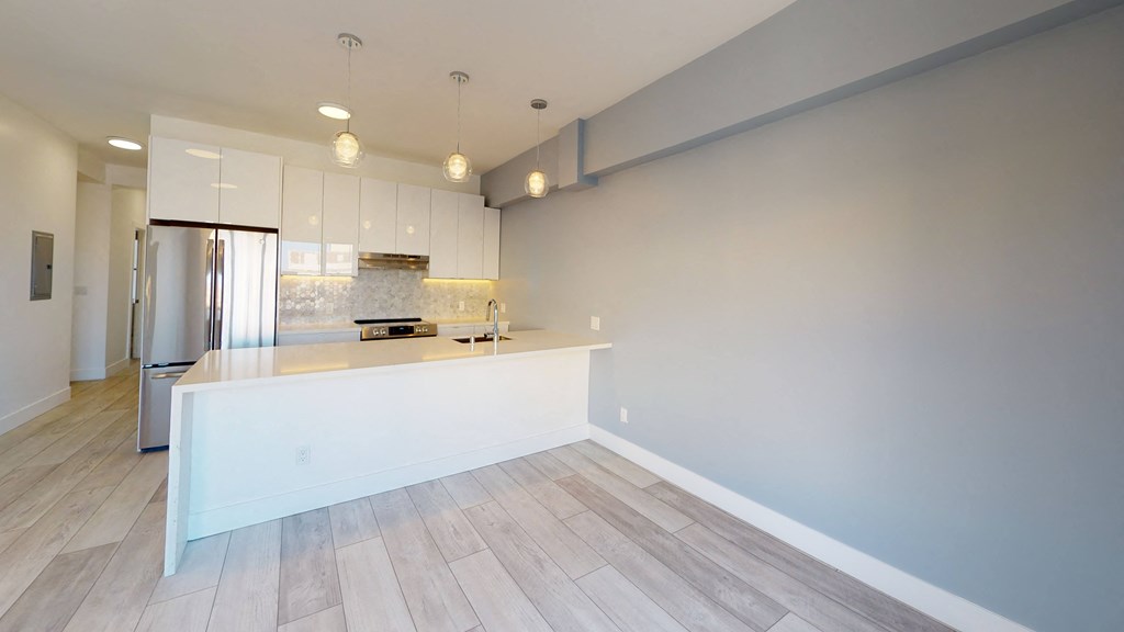 a kitchen with a white counter top and a stainless steel refrigerator