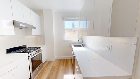 A kitchen with white cabinets and a black stove top oven.