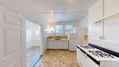 A kitchen with a stove top oven and a window.