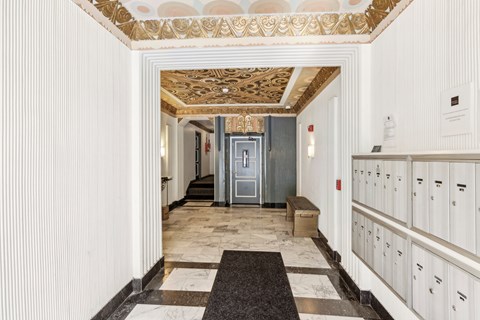 A hallway with a bench and a door at the end.