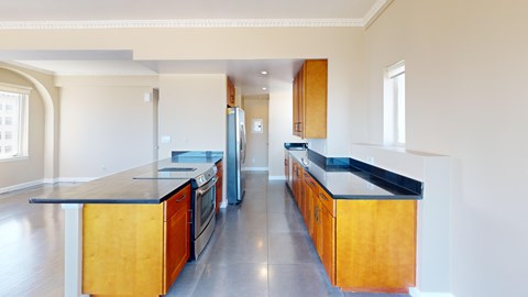 A kitchen with wooden cabinets and a black countertop.