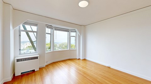 A room with a white wall and a wooden floor.