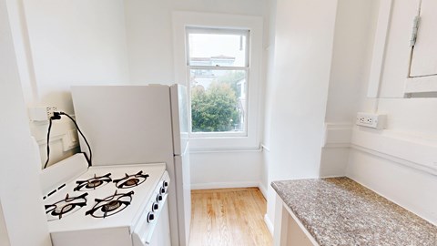 A white stove is in a kitchen with a window.