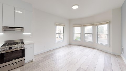 A kitchen with a stove top oven and a window.