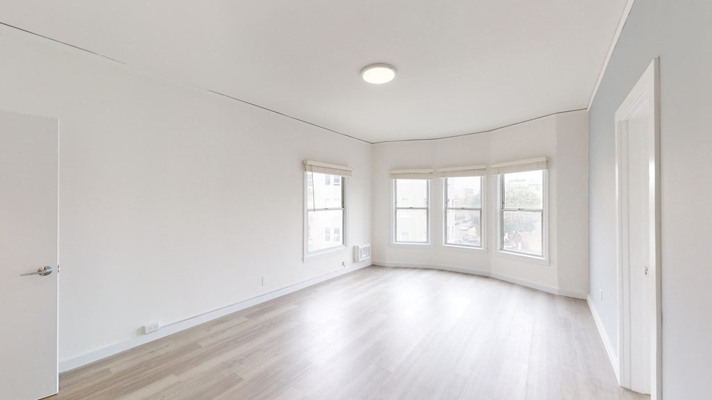 an empty living room with white walls and wood floors