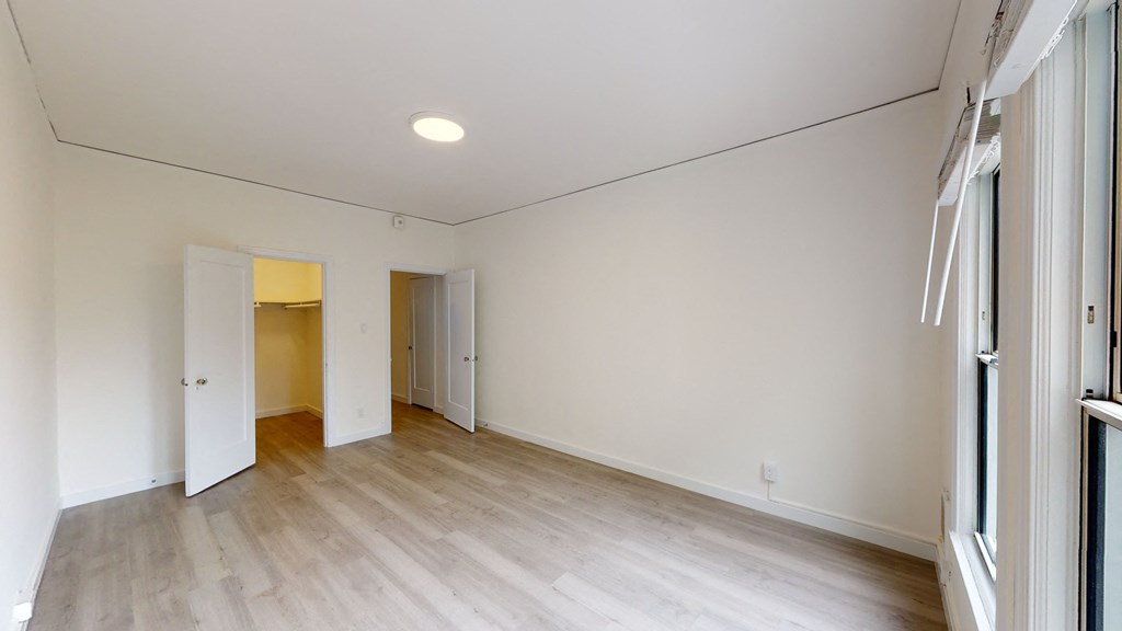 a living room with white walls and wood floors