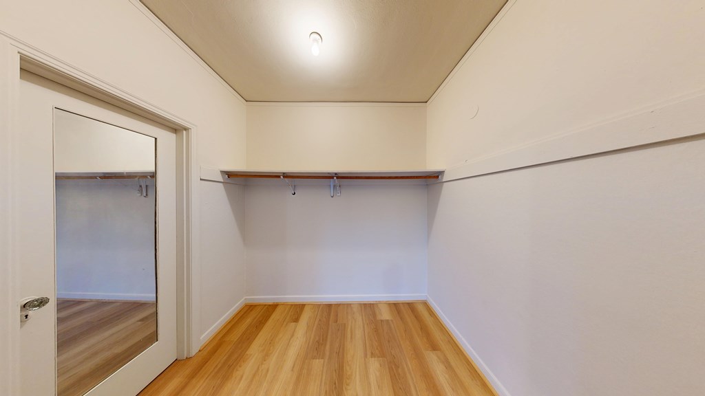 A room with a wooden floor and a white door.