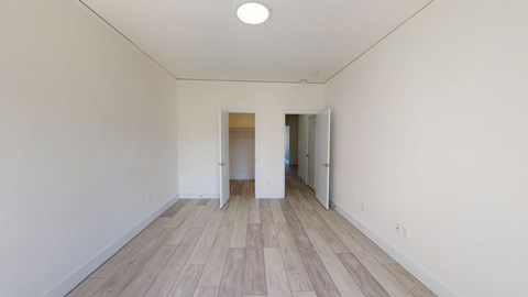 A room with wooden flooring and white walls.