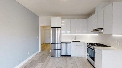 A modern kitchen with white cabinets and stainless steel appliances.