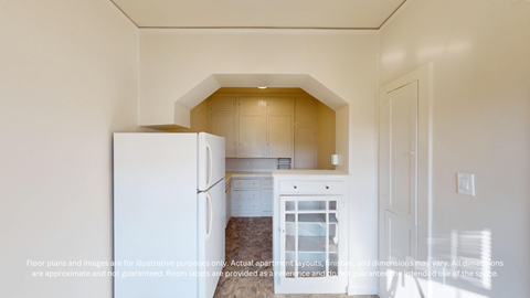 A white refrigerator is in a kitchen with a white door.