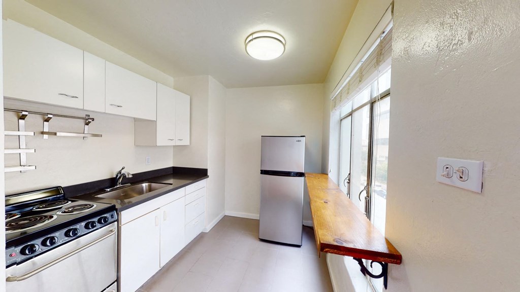 a kitchen with white cabinets and a stainless steel refrigerator