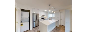 a white kitchen with a large island and stainless steel appliances