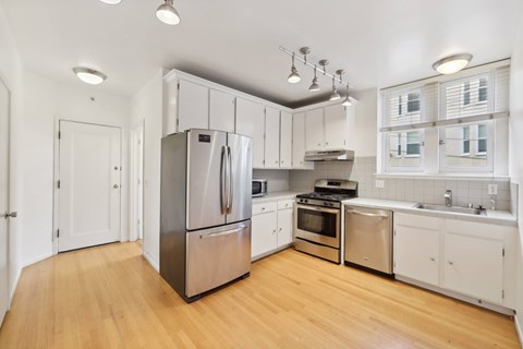 A kitchen with white cabinets and stainless steel appliances.