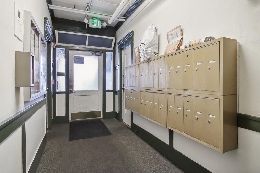 Hallway is lined with mailboxes, floor is covered in a carpet