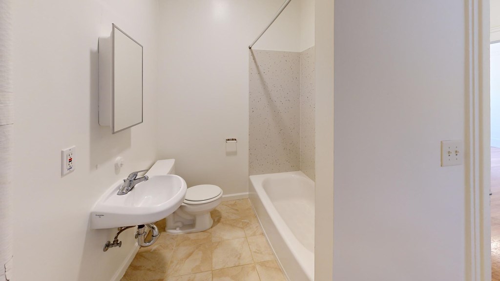 A white bathroom with a sink, toilet and bathtub.