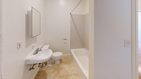 A white bathroom with a sink, toilet and bathtub.