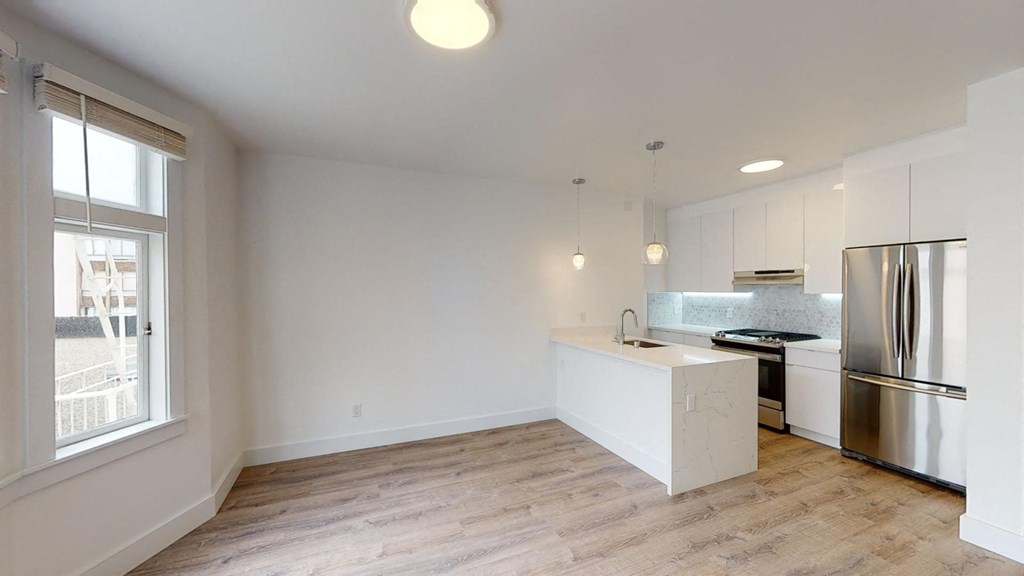 a kitchen with white cabinets and a stainless steel refrigerator