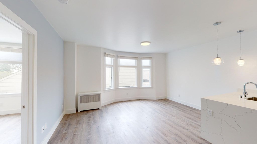 an empty living room with white walls and a window