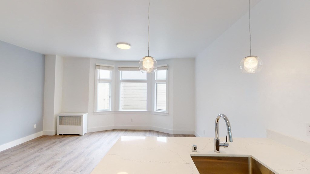 an empty kitchen with white walls and a large window