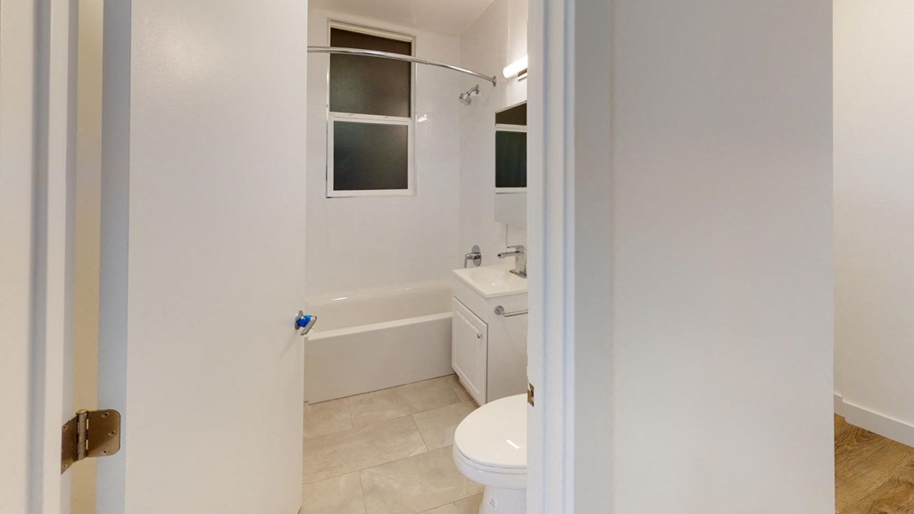 a bathroom with a toilet and a tub and a sink