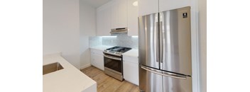 a kitchen with white cabinets and a stainless steel refrigerator
