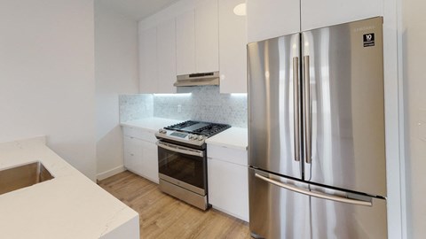 a kitchen with white cabinets and a stainless steel refrigerator