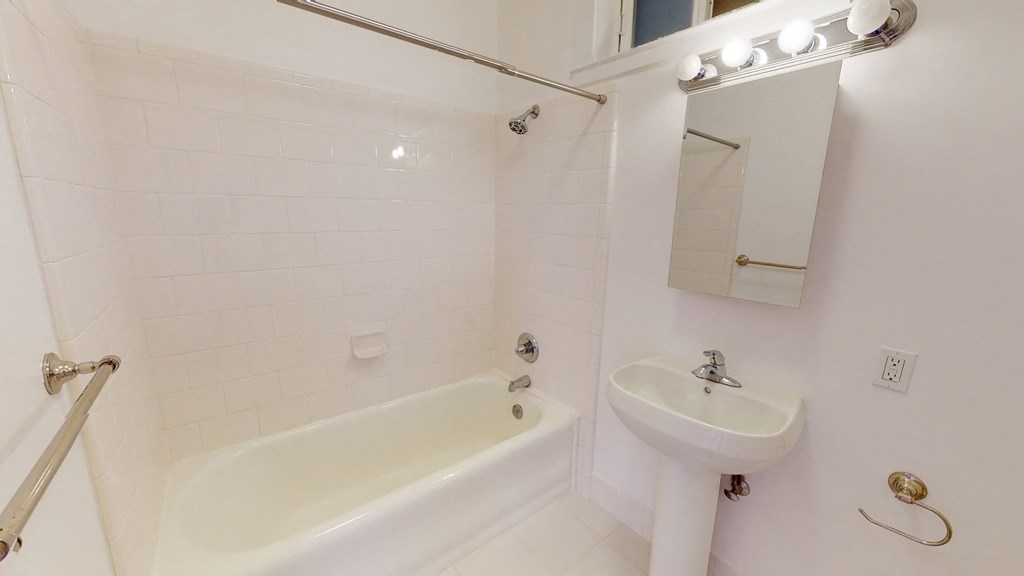 a bathroom with a sink and a tub and a mirror