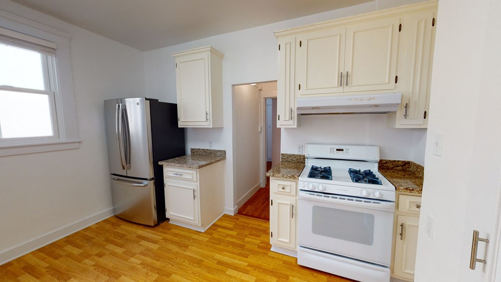 a kitchen with white appliances and white cabinets and a refrigerator
