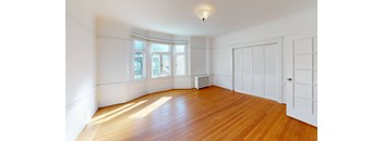 an empty living room with white walls and wood floors