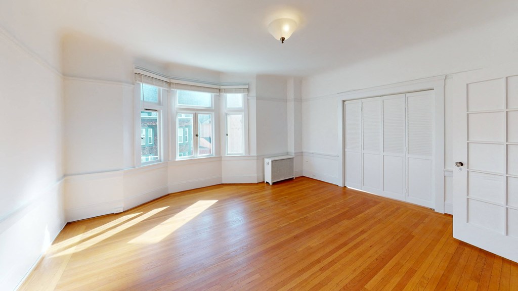an empty living room with white walls and wood floors