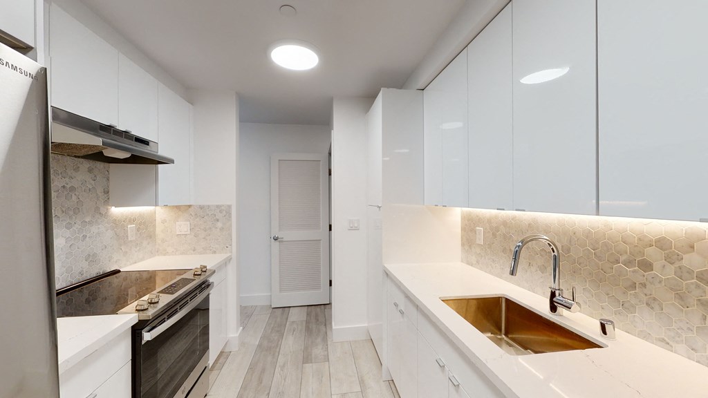 a large white kitchen with white cabinets and a sink