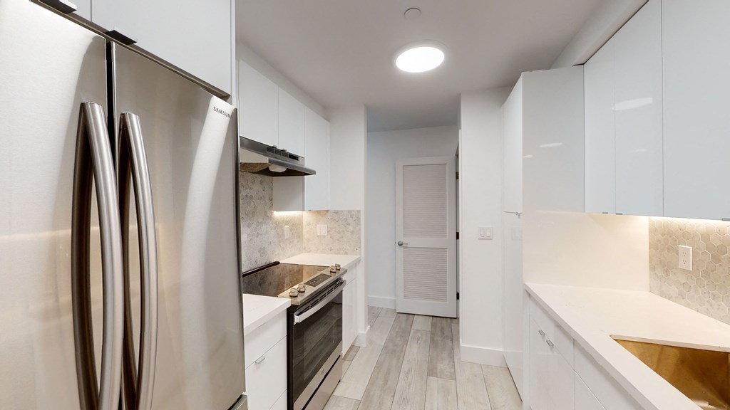 a renovated kitchen with white cabinets and stainless steel appliances