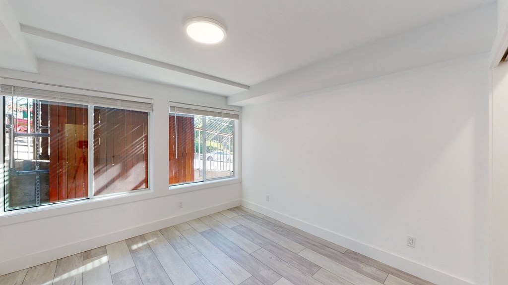 a living room with white walls and a large window