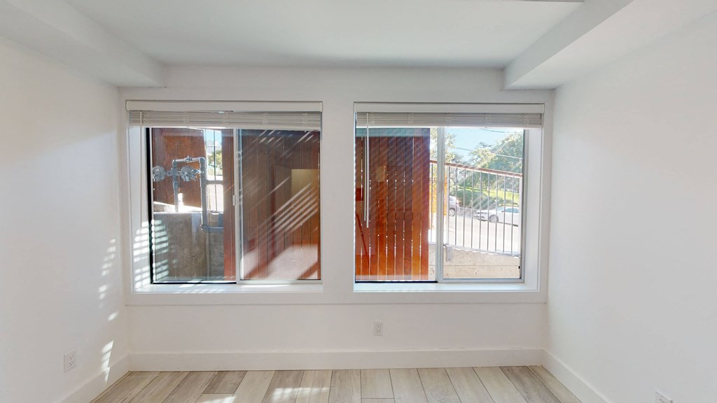 a living room with two windows and a wooden staircase
