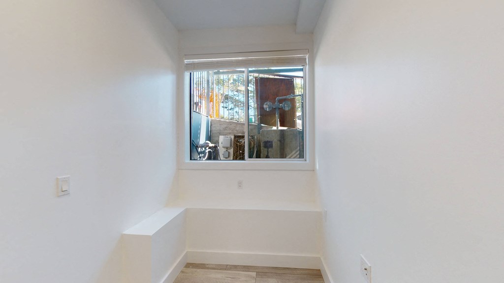 a small room with a window and a white wall