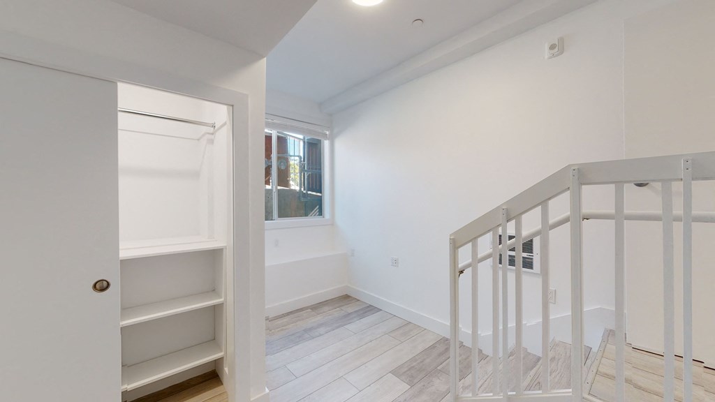 a white room with a staircase and a window and a white door