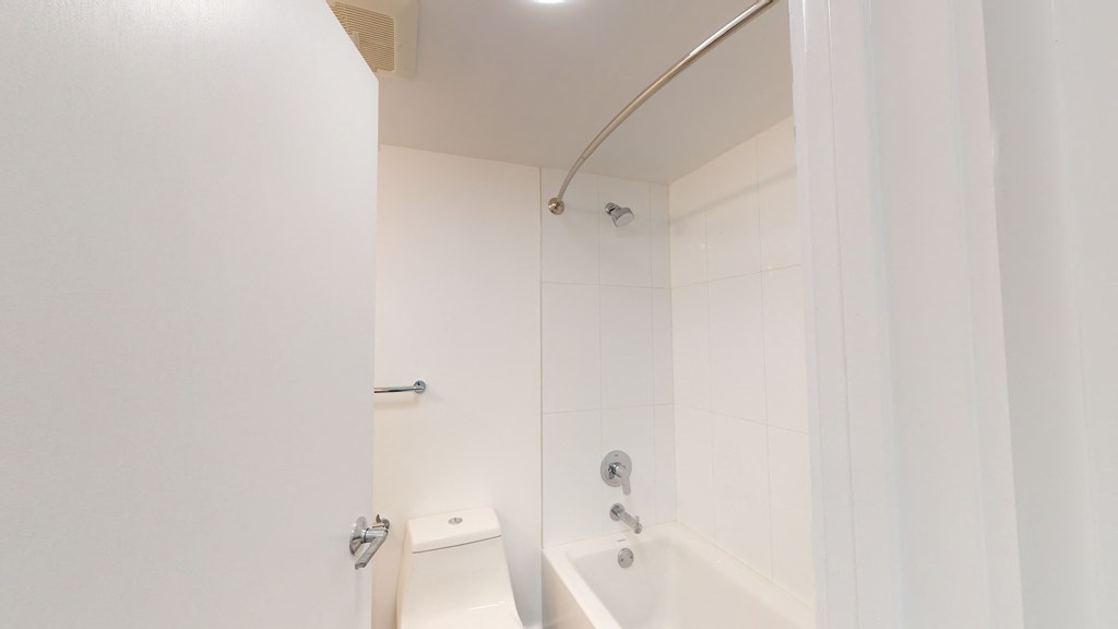 a white bathroom with a shower and a toilet