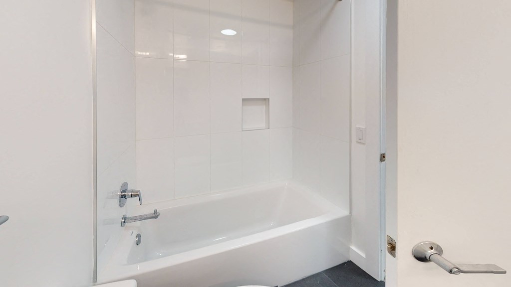 a white bathroom with a tub and a shower