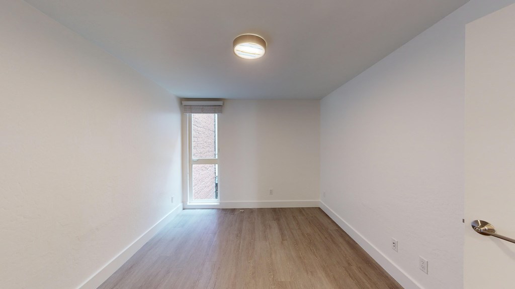 a living room with white walls and a window