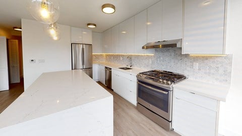 a kitchen with white cabinets and white counter tops and a stove